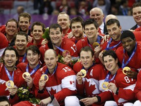 Canada players pose with their medals after beating Sweden 3-0 in the men's ice hockey gold medal game at the 2014 Winter Olympics, Sunday, Feb. 23, 2014, in Sochi, Russia.
