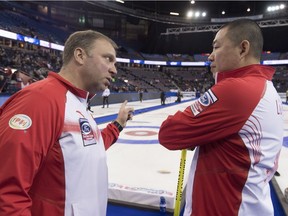 China coach Marcel Rocque speaks to skip Rui Liu during the 10th draw against Canada at the Men's World Curling Championships in Edmonton, Tuesday, April 4, 2017.