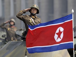 A North Korean national flag flutters as soldiers in tanks salute to North Korean leader Kim Jong Un during a military parade in Pyongyang, North Korea to celebrate the 105th birth anniversary of Kim Il Sung, the country's late founder and grandfather of the current ruler. A North Korean mid-r