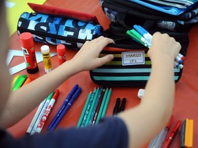 A child prepares school supplies.