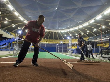 Ground crew works on the bullpen behind the outfield wall at Olympic Stadium, Saturday, April 1, 2017 in Montreal.