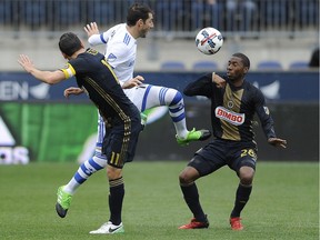 Impact midfielder Ignacio Piatti kicks the ball past Philadelphia Union defender Ray Gaddis, left, and midfielder Alejandro Bedoya (11) during the first half Saturday's match in Philadelphia.