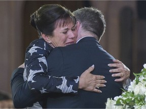 Mireille Deyglun is hugged by André Robitaille during the funeral for her mother, actress Janine Sutto in Montreal, Monday, April 10, 2017.