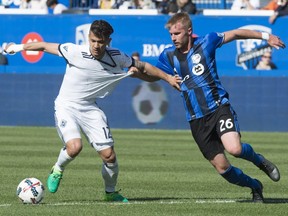 Impact defender Kyle Fisher hangs on to Vancouver Whitecaps forward Fredy Montero as they battle for the ball during second half MLS action Saturday, April 29, 2017, in Montreal.