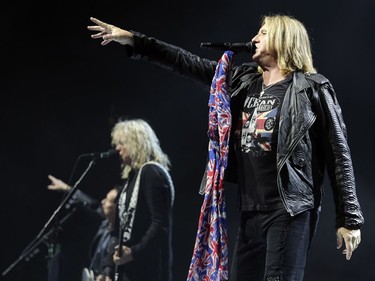 Def Leppard singer Joe Elliott performs with bass player Rick Savage and guitar player Vivian Campbell, left, during concert in Montreal Monday April 10, 2017.