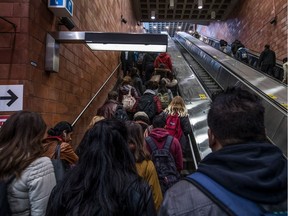 Commuters are directed to the staircase, left, and the escalator, right, as maintenance is carried out on the centre escalator at the Du Collège metro station in Ville St-Laurent, on Thursday, April 13, 2017.