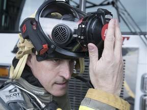 Pincourt fire chief Yanick Bernier puts on one of the new Scott Sight Integrated Thermal Camera Masks at the Pincourt fire station on Monday.