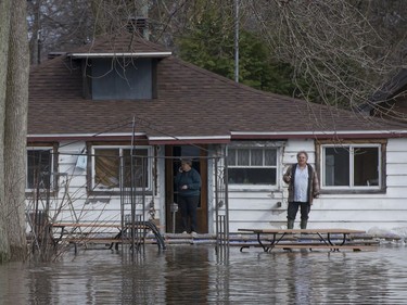 A couple watch the river water flow past their home on Ile Mercier in Île Bizard,April 20, 2017.