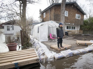 MONTREAL, QUE.: APRIL 20, 2017 --  Marvin Solido watches the water flow by the from of his home on Ile Mercier in Ile Bizard, in the Montreal borough of l'Ile-Bizard-Sainte-Genevieve on Thursday, April 20, 2017. (Peter McCabe / MONTREAL GAZETTE) ORG XMIT: 58479