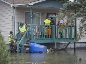 In this file photo from April 22, Sûrete du Québec officers and town officials check on residents whose homes have been flooded by the overflowing Ottawa River in Rigaud, Quebec west of Montreal. While Rigaud and other Montreal area communities remain on flood watch, communities downriver are feeling the effects of heavy rains and the spring thaw.