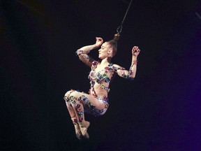 An acrobat performs while suspended by her hair during the opening performance of Volta, a Cirque du Soleil production.