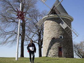 Claude Arsenault, who heads the Société pour la Sauvegarde du Patrimoine de Pointe-Claire, stands next to the historic windmill in Pointe-Claire Village last year.