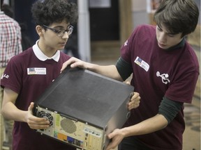 Mohamed Hamdaoui, left, and Michka Dreyfus get in on the repair action at the Réparothon held at Collège Ville-Marie in February, the first time Insertech teamed up with a high school.