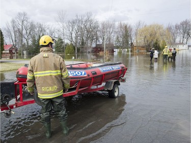 Members of the Rigaud's emergency services lower a boat on to a street in the town of Rigaud, Que., west of Montreal, Thursday, April 20, 2017, following flooding in the area. A state of emergency has been issued for the town.