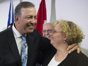 Quebec government MNA Sam Hamad hugs staff member Ihssane El Ghernati, right, as he leaves a news conference after he announced his resignation, Thursday, April 27, 2017 in St-Augustin-de-Desmaures.