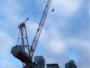 A woman is seen clinging to the pulley of a high construction crane in downtown Toronto as a rescue worker attempts to free her.