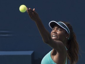 Canada's Françoise Abanda tosses the ball to serve to Elina Svitolina of Ukraine during second round of play at the Rogers Cup tennis tournament on July 27, 2016, in Montreal.