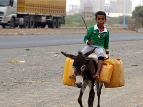 Photo of the day: A Yemeni boy rides a donkey carrying plastic containers full of water in an impoverished coastal village on the outskirts of the Yemeni port city of Hodeidah, April 17, 2017.