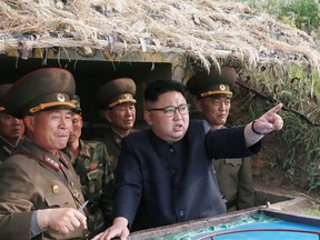 North Korea leader Kim Jong-un seen here consulting with his military leaders.