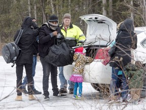 In this file photo, a group of refugee claimants from Eritrea arrive by taxi to cross the border from New York into Canada, Thursday, March 2, 2017 in Hemmingford, Quebec.