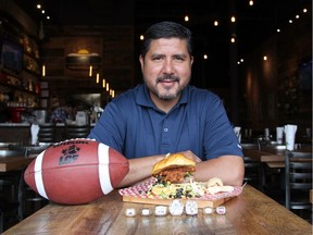 Alouettes great Anthony Calvillo with his namesake burger at Notre-Boeuf-De-Grâce on Sherbrooks St. W.  The $14, six-ounce burger, made of fresh ground beef, is topped with chorizo, a Mexican sausage, roasted corn relish, Nappa Jicama coleslaw and is served with a side of Chicharron.