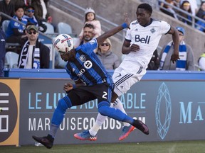 Montreal Impact defender Ambroise Oyongo and Vancouver Whitecaps forward Alphonso Davies battle for the ball during second half MLS action Saturday, April 29, 2017 in Montreal.