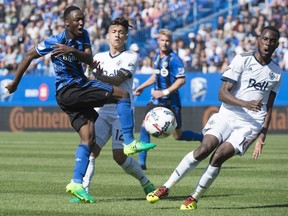 Montreal Impact midfielder Ballou Tabla kicks the ball away from Vancouver Whitecaps forward Fredy Montero and midfielder Tony Tchani, right, during first half MLS action Saturday, April 29, 2017 in Montreal.