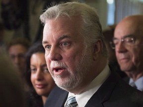 Quebec Premier Philippe Couillard, centre, speaks to reporters at a news conference to comment the Bombardier C-Series deal with Delta Airlines, before a party caucus meeting, Thursday, April 28, 2016 at the legislature in Quebec City. Couillard says the province needs to take care of Bombardier because of its unique importance to the province.THE CANADIAN PRESS/Jacques Boissinot