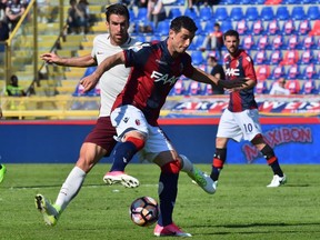 Bologna's midfielder from Switzerland Blerim Dzemaili (front) fights for the ball with Roma's midfielder from Netherlands Kevin Strootman during the Italian Serie A football match Bologna vs AS Roma in Bologna on April 9, 2017.