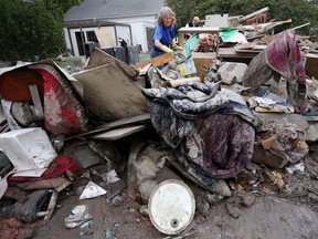 After the flood, the cleanup: Melanie Swailes sorts through her parents possessions in Calgary 
in 2013.
