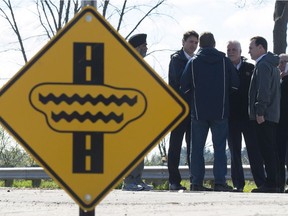 Minister of National Defence Minister Harjit Sajjan, left, Canadian Prime Minister Justin Trudeau, Quebec Premier Philippe Couillard, Gatineau MP Steven McKinnon and Public Safety and Emergency Preparedness Minister Ralph Goodale speak with Gatineau Mayor Maxime Pedneaud-Jobin as they tour a flooded area in Gatineau, Que. Thursday May 11, 2017.