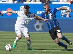 Montreal Impact defender Kyle Fisher hangs on to Vancouver Whitecaps forward Fredy Montero as they battle for the ball during second half MLS action Saturday, April 29, 2017 in Montreal.