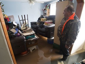 Flood waters lap at his feet as Marcel Theriault looks at his living room on the main floor of his home Sunday, May 7, 2017 in Gatineau.