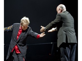 Elton John bows in front of Billy Joel at the top of their concert at the Bell Centre in Montreal on June 3, 2009.