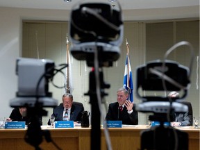 Pointe-Claire Mayor Morris Trudeau, centre, answers questions during a city council meeting.