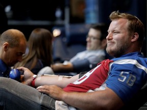 Montreal Alouettes' Luc Brodeur-Jourdain gives blood during the Montreal Alouettes annual blood drive held in collaboration with Hema-Quebec in Montreal on Wednesday May 11, 2016.