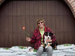 Christine Tanzer was one of many served a Mother's Day breakfast and given a rose by volunteers in the Terrase-Vaudreuil district of Montreal on Sunday May 14, 2017. Tanzer holds her dog, Elle on the sandbag wall that helped keep the water at bay in her father's home. Johann Tanzer was the designer of the famous sailboats used in the Olympic games. (Allen McInnis / MONTREAL GAZETTE)