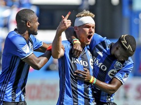 Montreal Impact's Kyle Fisher celebrates his goal with teammates Chris Duvall, left, and Ambroise Oyongo during first half MLS action against the Portland Timbers in Montreal on Saturday May 20, 2017.  Fisher's head was bandaged following a collision with an opposition player.
