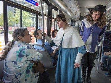 Actors impersonating Jeanne Mance left, and Paul de Chomedey, Sieur de Maisonneuve, speak to a bus rider during Montreal Museums Day, when 43 local art institutions open their doors, free of charge for citizens to explore at will in Montreal, on Sunday, May 28, 2017.