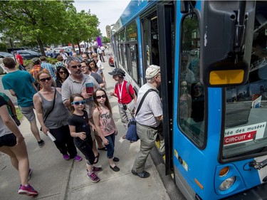 Montrealers line up at Promenade des artistes in the Quartier des spectacles for one of the many free busses that shuttle people during Montreal Museums Day on Sunday, May 28, 2017.