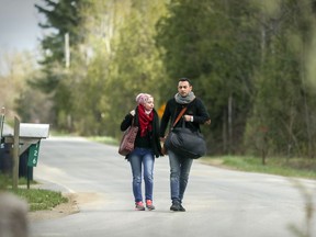 A couple from Syria walk down the U.S. side of Roxham Rd. on May 3 on their way to crossing illegally into Canada at Hemmingford.