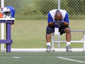 Alouettes quarterback Darian Durant rests his head in his hands after injuring his left knee during training camp at Bishop's University in Lennoxville on Tuesday.