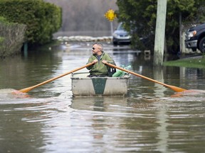 Andrew Szyngiel rows to his home at the end of flooded De Gaulle St. in Pierrefonds-Roxboro May 4, 2017.