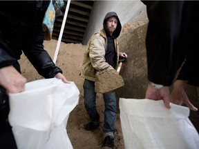 Luke Woodyard volunteers to fill sandbags for flood victims in Hudson last Friday.