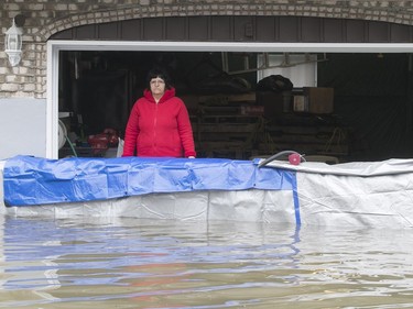 A resident stands buy het flooded garage on rue Jean-Yves in Ile Bizard on Saturday May 6, 2017. (Pierre Obendrauf / MONTREAL GAZETTE)