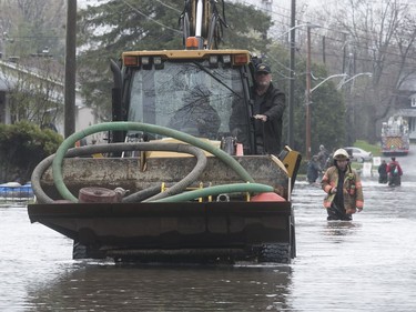 Pumps arrive in a front-end loader on flooded Jean-Yves St. in Ile Bizard on Saturday May 6, 2017. (Pierre Obendrauf / MONTREAL GAZETTE)