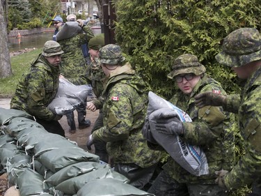 Canadian military personnel from Valcartier shore up a sandbag wall along a house on Bouchard St. in Pierrefonds May 7, 2017.