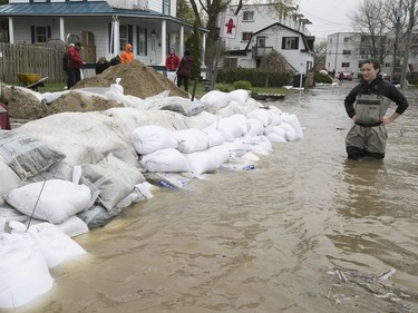 Valerie Turcotte, right, has a look at all the sandbags surrounding her St-Martin St. triplex in Pierrefonds on Sunday, May 7, 2017.