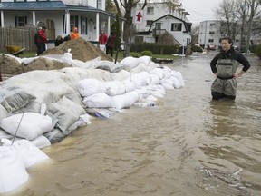Valérie Turcotte, right, has a look at all the sandbags surrounding her Saint-Martin street triplex in Pierrefonds on Sunday May 7, 2017.