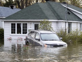 A car sits half-submerged at a home in Deux Montagnes, northwest of Montreal, May 8, 2017.